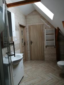 baño con 2 lavabos y puerta de madera en Sielskie Klimaty, en Marcinowice