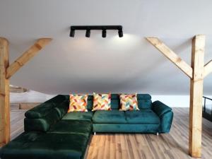 uma sala de estar com um sofá verde e pisos em madeira em Sielskie Klimaty em Marcinowice