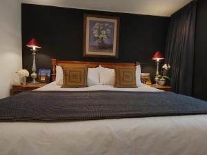 a bedroom with a large bed with black walls at ANA FRANK Boutique Hotel in Lima