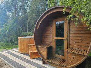 a wooden sauna with a large window and a barrel at Sielskie Klimaty in Marcinowice