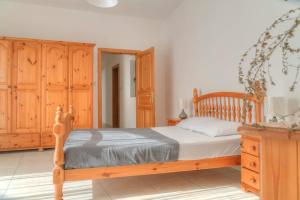 um quarto com uma cama de madeira e armários de madeira em Double bedroom with ensuite in spacious corner apartment em Birkirkara