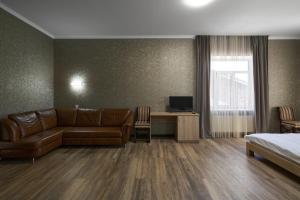a hotel room with a couch and a bed at Podil City View in Kyiv