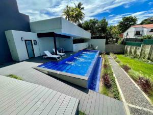 una casa con piscina en el patio trasero en Sky Flat Panoramic View 2Brm@Avitat Link w/Pool &Gym, en Antiguo Cuscatlán