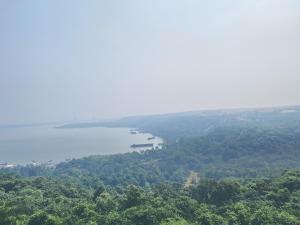 a view of a lake with a boat in the water at Premium 2BHK -10 min to GOI airport & beach -Pool access -Balcony with city view in Dabolim +53 photos