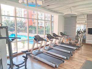 a row of treadmills in a gym with a pool at Premium 2BHK -10 min to GOI airport & beach -Pool access -Balcony with city view in Dabolim