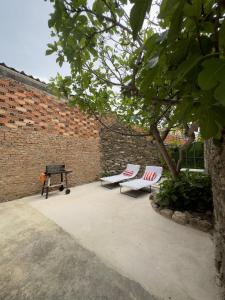 a patio with two chairs and a picnic table and a brick wall at SAN ISIDRO in Migueláñez
