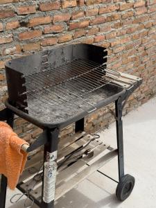a barbecue grill sitting in front of a brick wall at SAN ISIDRO in Migueláñez