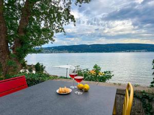 - une table avec deux verres de vin et des fruits dans l'établissement Ferienwohnung Findling, à Île de Reichenau