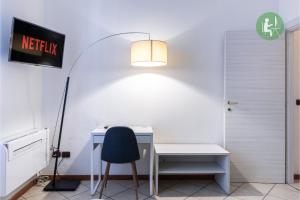 escritorio con silla y una luz en la pared en Wonderful Double Rooms - Comfort in CityLife - near METRO - FREE PARKING, en Milán