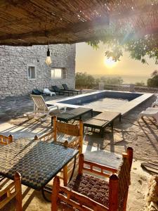 Chill House surf camp في سيدي كاوكي: فناء به طاولات وكراسي ومسبح