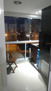 a room with a balcony with a table and a chair at Apartamento no mar grosso,alto padrao in Laguna