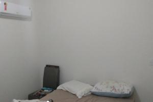 a bed with two pillows in a room at Apartamento no mar grosso,alto padrao in Laguna