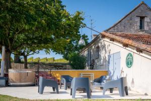 a group of chairs sitting outside of a building at Gîte Barn - Tirecul - 24 in Bergerac