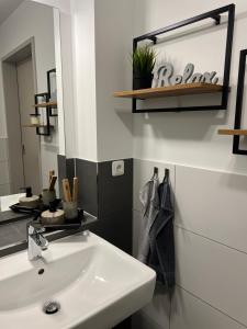 a bathroom with a white sink and a mirror at Charming Homes - Studio 25 in Wolfsburg