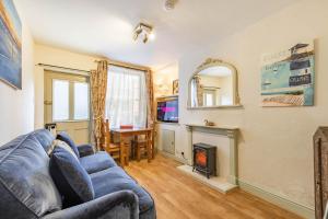 a living room with a blue couch and a fireplace at Fishermans Cottage - Norfolk Holiday Properties in Cromer