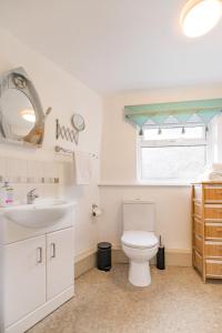 a bathroom with a white toilet and a sink at Fishermans Cottage - Norfolk Holiday Properties in Cromer