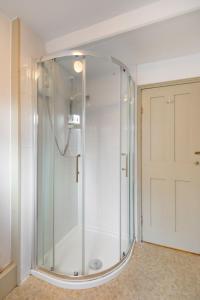 a shower with a glass door in a bathroom at Fishermans Cottage - Norfolk Holiday Properties in Cromer