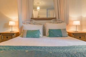 a bedroom with a bed with two lamps and a mirror at Fishermans Cottage - Norfolk Holiday Properties in Cromer