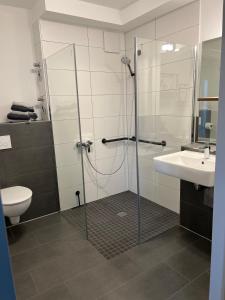 a bathroom with a shower and a toilet and a sink at Charming Homes - Studio 25 in Wolfsburg