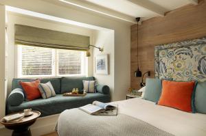 a bedroom with a blue couch and a bed at The Gallivant in Rye