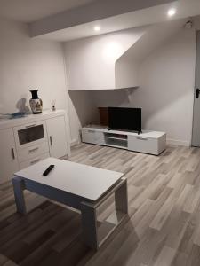 ein weißes Wohnzimmer mit einem TV und einem Tisch in der Unterkunft Apartamento Triana in Alovera