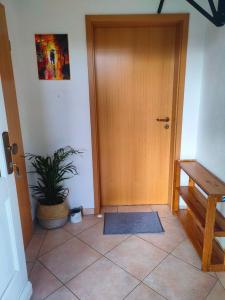 a hallway with a wooden door and a potted plant at Neuenhagen Haven in Neuenhagen +12 photos