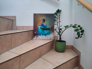 a painting of a woman in a blue dress next to a plant at Neuenhagen Haven in Neuenhagen