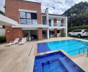 une maison avec une piscine en face d'une maison dans l'établissement Casa Campestre con piscina, à San Jerónimo