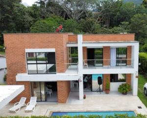 une maison en briques avec une piscine en face de celle-ci dans l'établissement Casa Campestre con piscina, à San Jerónimo