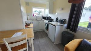 a small kitchen with a table and a table and a dining room at 89 Florida Park in Hemsby