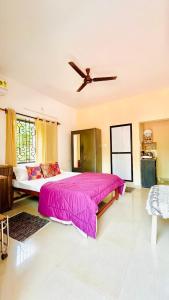 a bedroom with a large bed with a ceiling fan at Mitra Homes Mandrem in Mandrem +57 photos