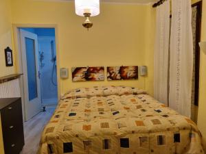 a bedroom with a bed and a yellow wall at LA CORTE DELLA CARLA - cozy home in the old court in Lierna