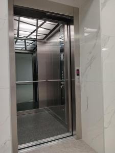 une porte en verre menant à un ascenseur dans un immeuble dans l'établissement Apartments Karić Aerodrom Tuzla, à Dubrave Gornje