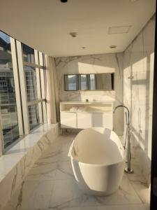 a white bathroom with a tub and a sink at Hotel Nacional Rio de Janeiro in Rio de Janeiro
