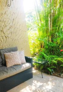 un salon avec un canapé et un jardin dans l'établissement 1br, 24hr security - City Charm with Poolside Peace, à Port-d'Espagne