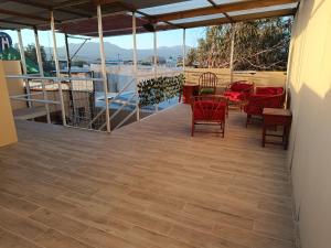 eine Terrasse mit Stühlen und Tischen und Blick auf das Wasser in der Unterkunft Hostal Ollague, habitaciones con baño privado in Calama