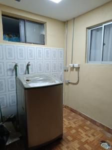 uma casa de banho com um lavatório e um chuveiro. em Hostal Ollague, habitaciones con baño privado em Calama