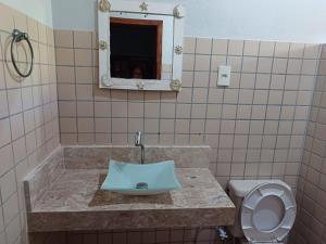 y baño con lavabo, aseo y espejo. en Chalé Seychelles, en Barra Grande