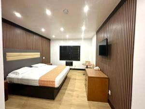 1 dormitorio con 1 cama y TV de pantalla plana en Casa Playa Inn & Suites Stanton Anaheim Area, en Stanton