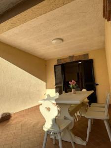 einen weißen Tisch und Stühle in einem Zimmer in der Unterkunft Casa Ninetta Marco Simone in Marco Simone