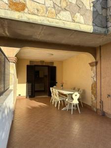 eine Terrasse mit einem Tisch und Stühlen in einem Gebäude in der Unterkunft Casa Ninetta Marco Simone in Marco Simone