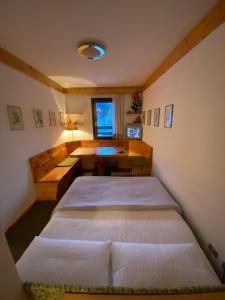 a small bedroom with two beds and a desk at Bilocale ad un passo dalle piste in Madonna di Campiglio