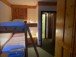 a bedroom with two bunk beds and a hallway at Bilocale ad un passo dalle piste in Madonna di Campiglio