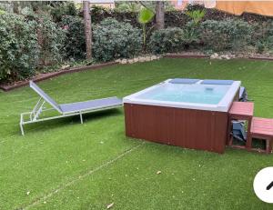 een hot tub en een bank in de tuin bij Apartamento abierto con patio in Matadepera