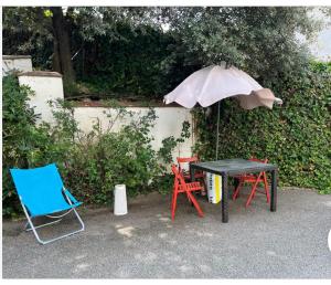 een tafel en twee stoelen en een paraplu bij Apartamento abierto con patio in Matadepera
