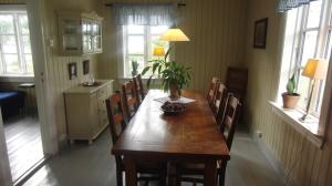 uma sala de jantar com uma mesa de madeira e cadeiras em Bårdstua em Stokmarknes