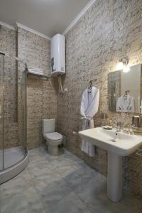 uma casa de banho com um lavatório, um WC e um chuveiro em Podil City View em Kiev
