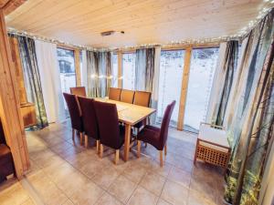 uma sala de jantar com mesa, cadeiras e janelas em Woody 13 em Sankt Lorenzen ob Murau