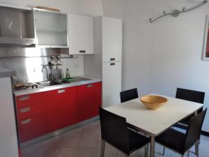 a kitchen with red cabinets and a table with chairs at Spacious 2 bedroom condo in Colletta