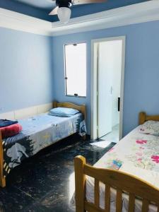two beds in a room with blue walls at Casa confortável p/13/14/18 pessoas c 4/5/6 suítes in Belo Horizonte
